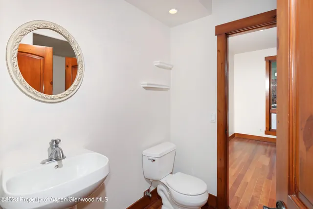 a bathroom with a toilet a sink and mirror