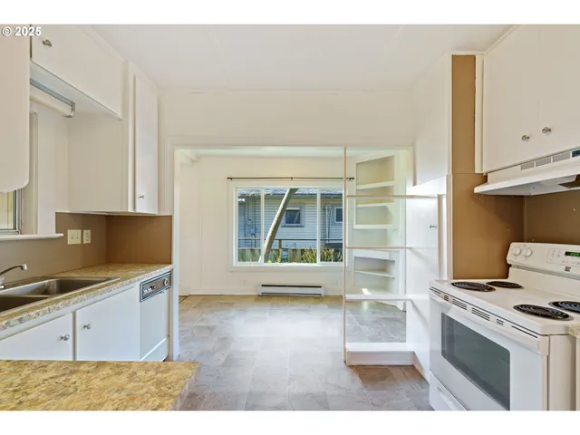 a kitchen with granite countertop a stove a sink and a microwave