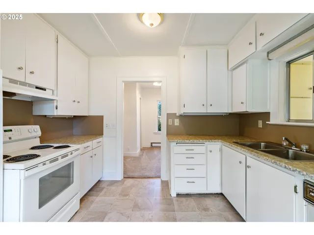 a kitchen with white cabinets and appliances