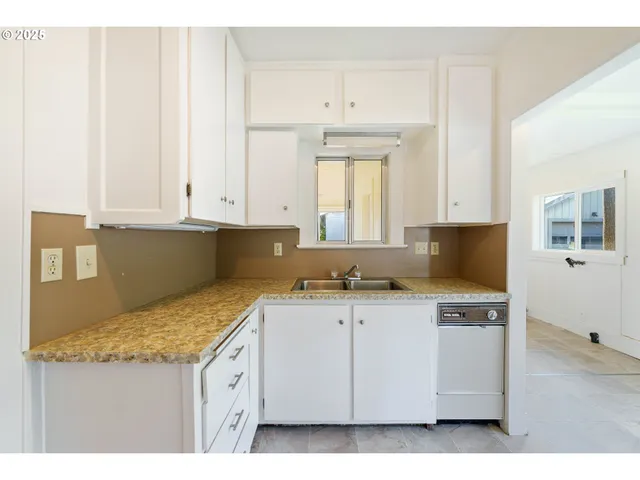 a kitchen with granite countertop a sink a stove and cabinets