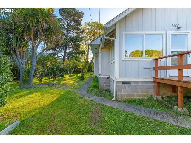 a view of an house with backyard and a tree