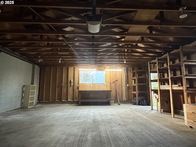 a view of an empty room with wooden floor and windows