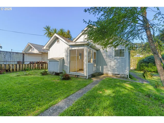 a view of a house with a big yard potted plants and large tree