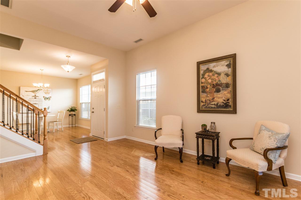 1317 Silver Beach Way Raleigh, NC 27606 - Photo 5 of 24 a living room with couches chairs and kitchen view with wooden floor