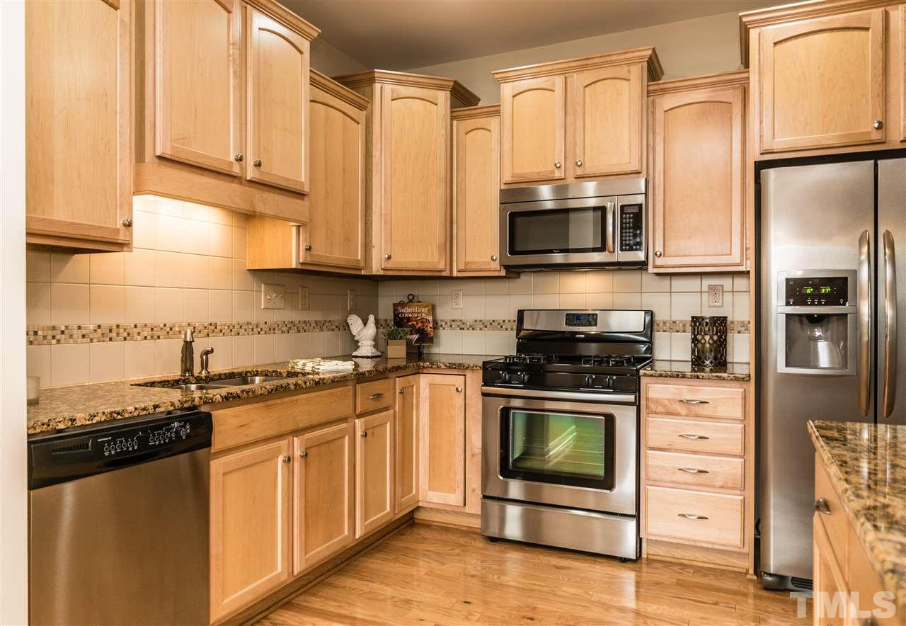 1317 Silver Beach Way Raleigh, NC 27606 - Photo 8 of 24 a kitchen with stainless steel appliances granite countertop a stove a sink and a refrigerator