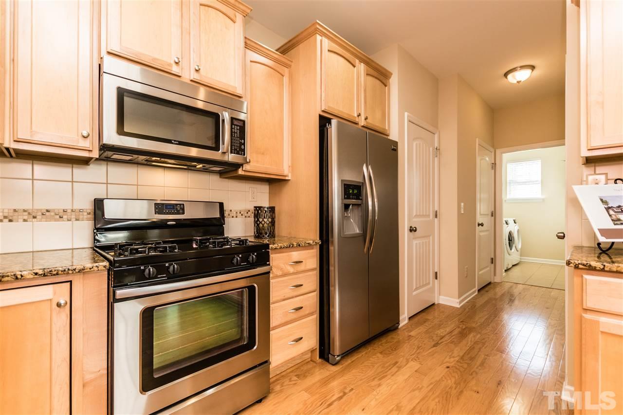1317 Silver Beach Way Raleigh, NC 27606 - Photo 10 of 24 a kitchen with stainless steel appliances a stove a microwave and cabinets