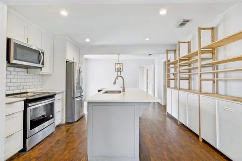 a kitchen with stainless steel appliances granite countertop a refrigerator and a stove top oven