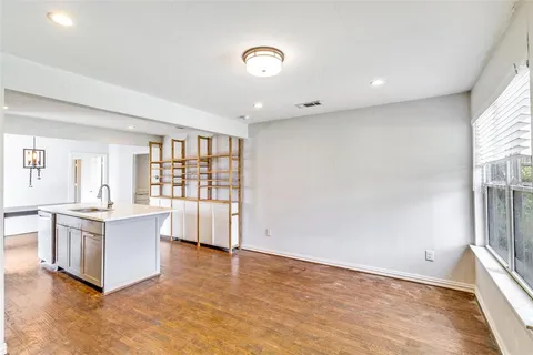 a view of a kitchen with a sink and dishwasher with wooden floor