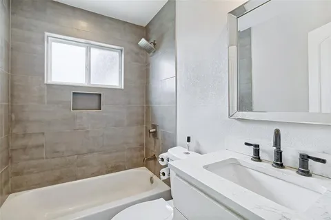 a bathroom with a granite countertop sink toilet and bathtub