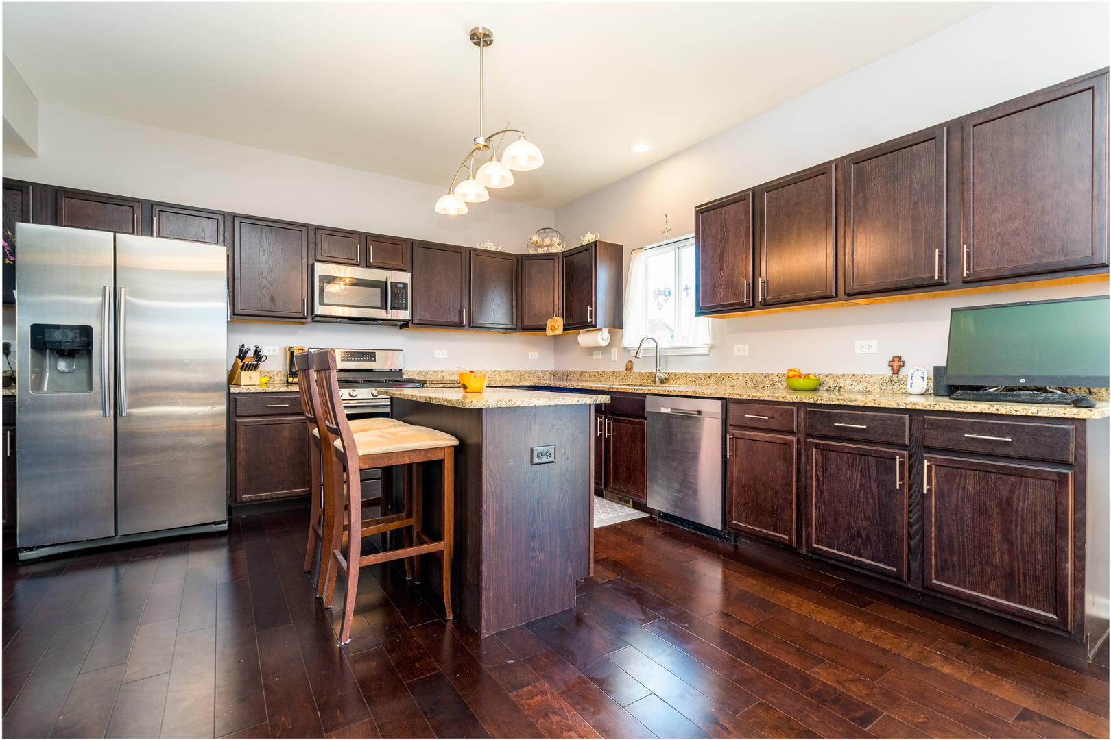 1604 Edentenny Road New Lenox, IL 60451 - Photo 4 of 37 a kitchen with stainless steel appliances granite countertop a refrigerator a stove a sink dishwasher a microwave oven with cabinets and wooden floor