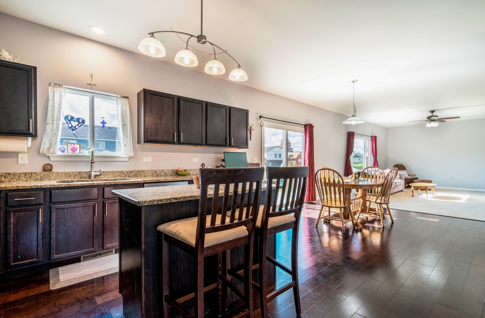 1604 Edentenny Road New Lenox, IL 60451 - Photo 6 of 37 a kitchen with stainless steel appliances granite countertop a stove a sink a dining table and chairs with wooden floor
