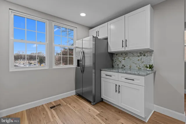 a kitchen with stainless steel appliances granite countertop a refrigerator and a stove top oven