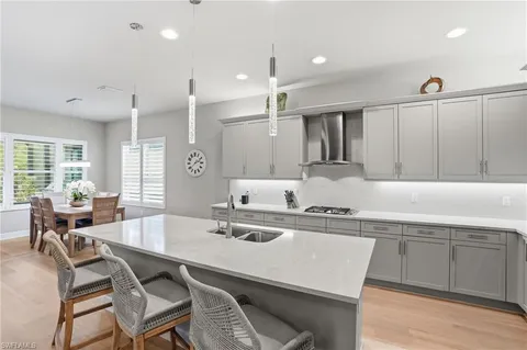 a kitchen with a dining table chairs sink and wooden floor