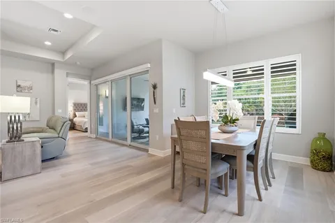 a dining room with furniture window and wooden floor
