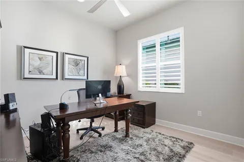 a view of a workspace with furniture and a window