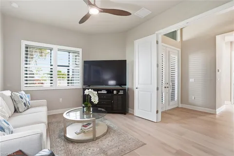 a living room with furniture a flat screen tv and a large window