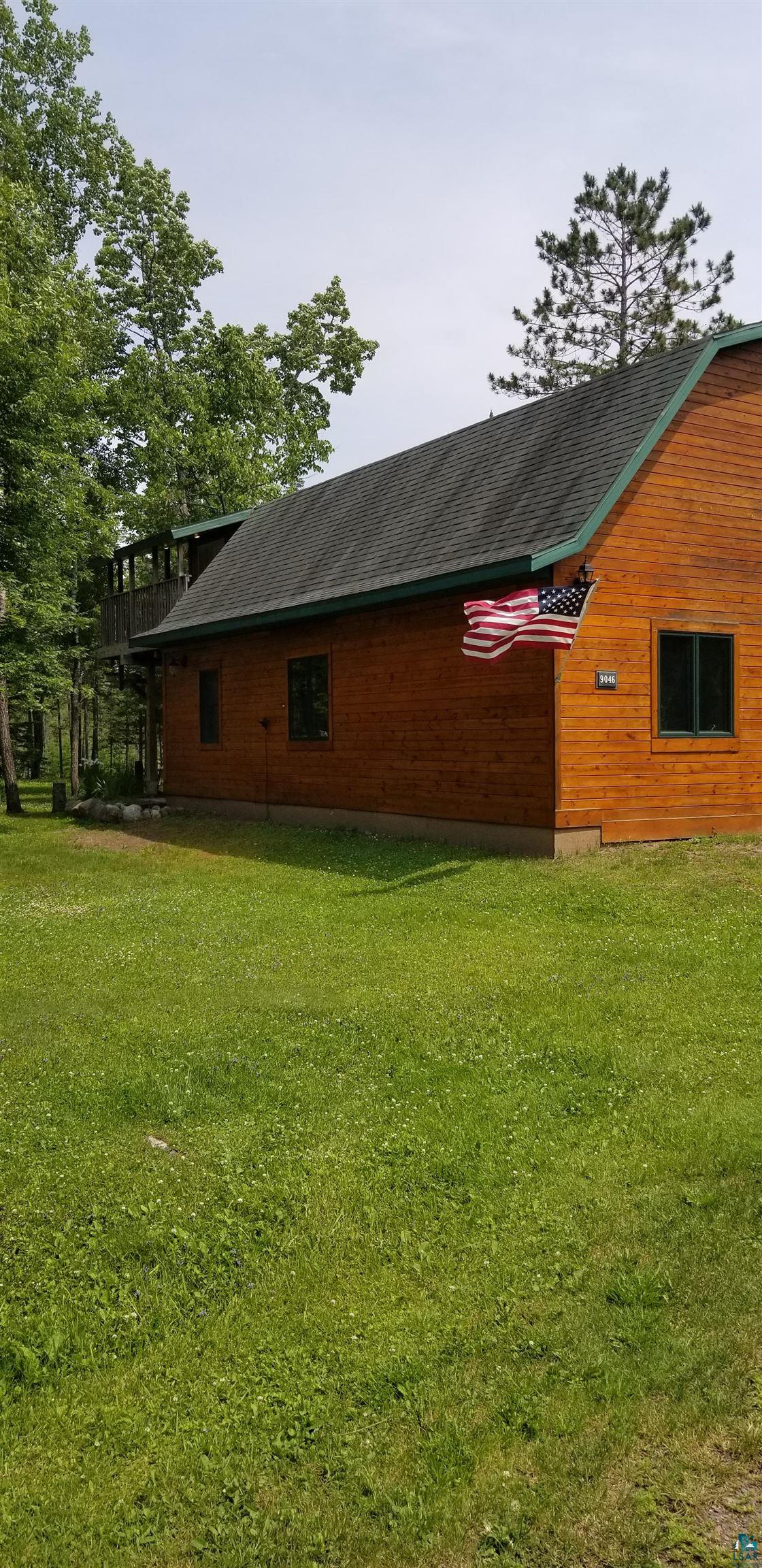 9046 Eagles Club Road Alborn, MN 55702 - Photo 24 of 28 Wood-sided exterior featuring a dark asphalt shingle roof with green trim