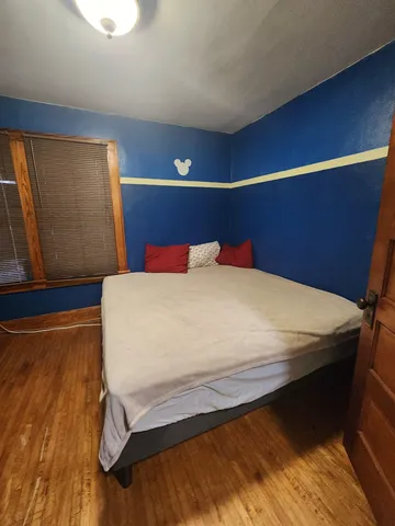 a bedroom with a bed and wooden floor