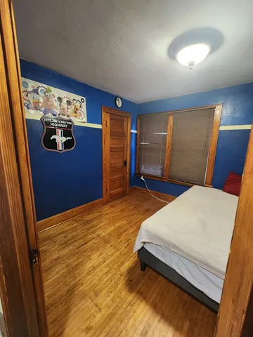 a bedroom with a large bed and a chandelier