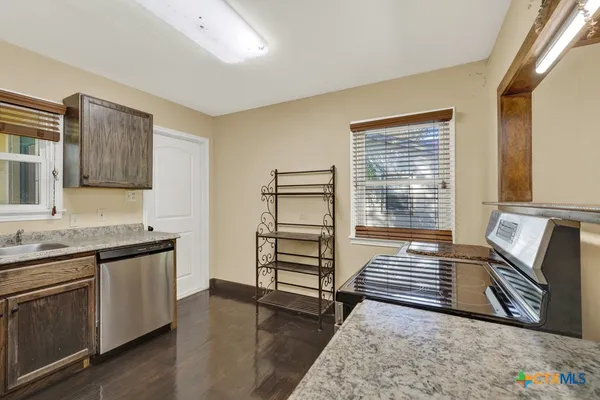 a kitchen with stainless steel appliances granite countertop a stove a sink and a refrigerator