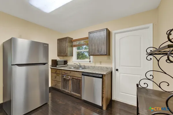 a kitchen with stainless steel appliances granite countertop a refrigerator and a sink