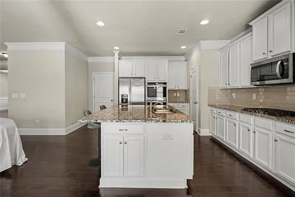 a kitchen with granite countertop a sink stove and cabinets