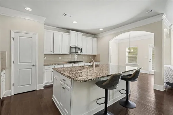 a kitchen with stainless steel appliances granite countertop a stove a sink and a refrigerator