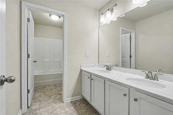a bathroom with a double vanity sink mirror and shower
