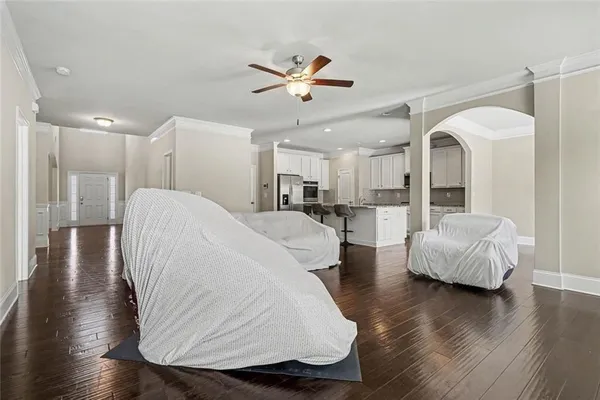 a living room with couches and a view of kitchen