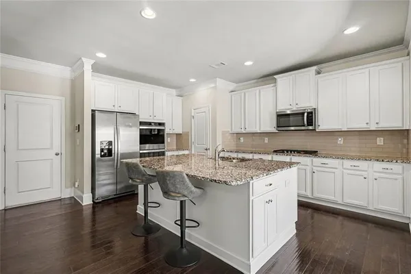 a kitchen with kitchen island granite countertop a sink cabinets and wooden floor
