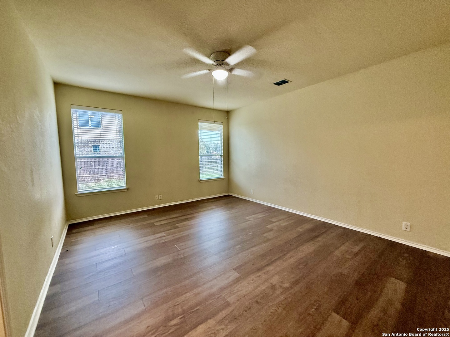 7015 Laguna Beach Converse, TX 78109 - Photo 13 of 39 a view of an empty room with wooden floor and a window