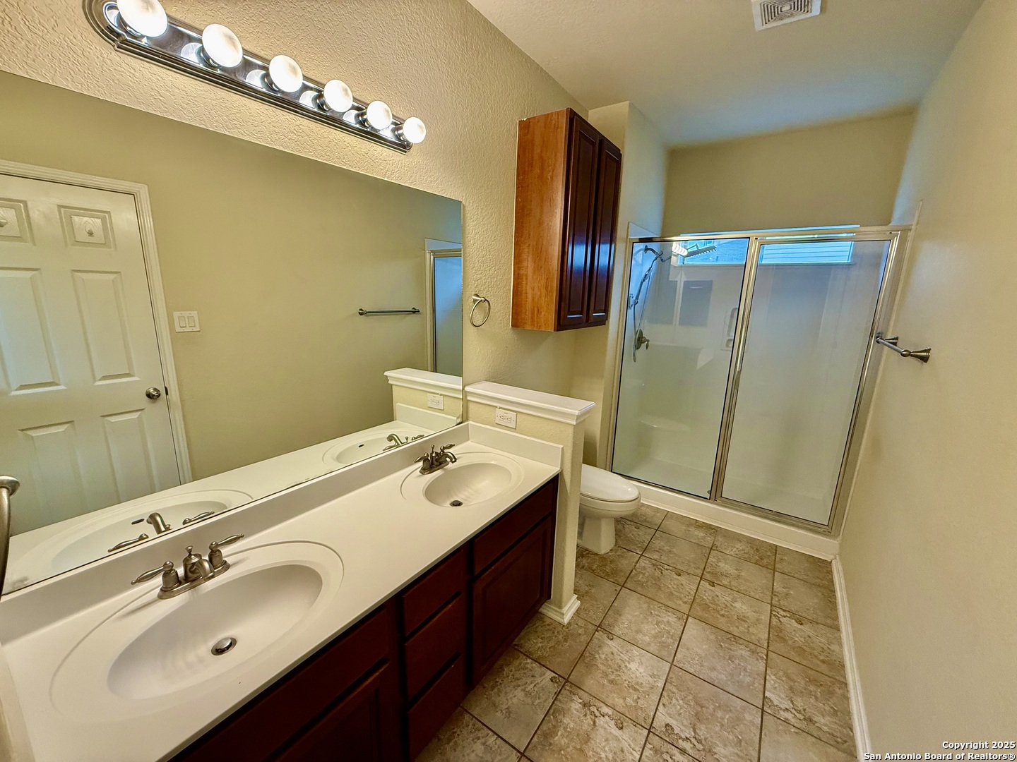 7015 Laguna Beach Converse, TX 78109 - Photo 16 of 39 a spacious bathroom with a double vanity sink a mirror and a shower