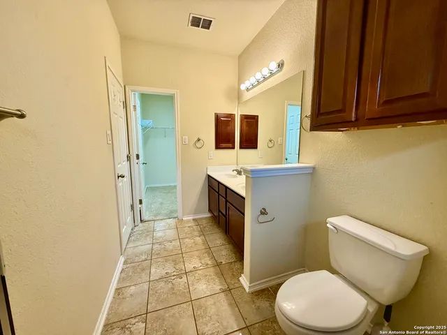 a bathroom with a toilet a sink and mirror