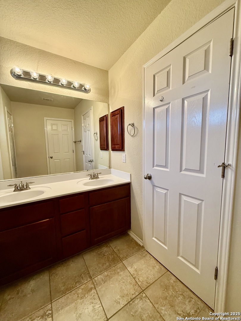 7015 Laguna Beach Converse, TX 78109 - Photo 35 of 39 a bathroom with a double vanity sink and mirror