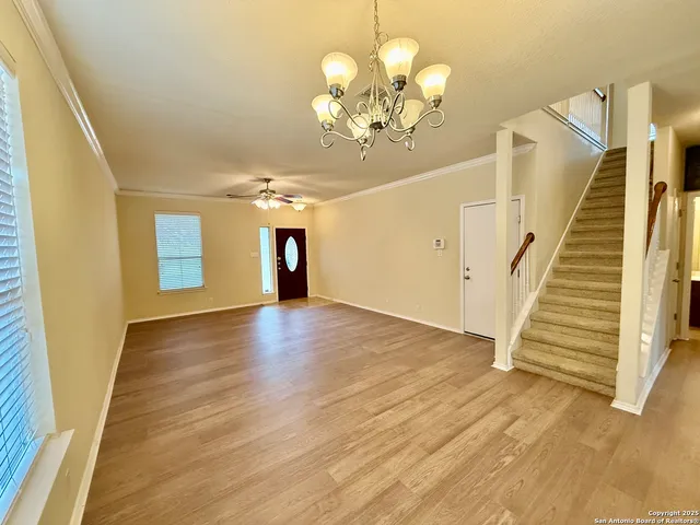 a view of a livingroom with wooden floor and stairs