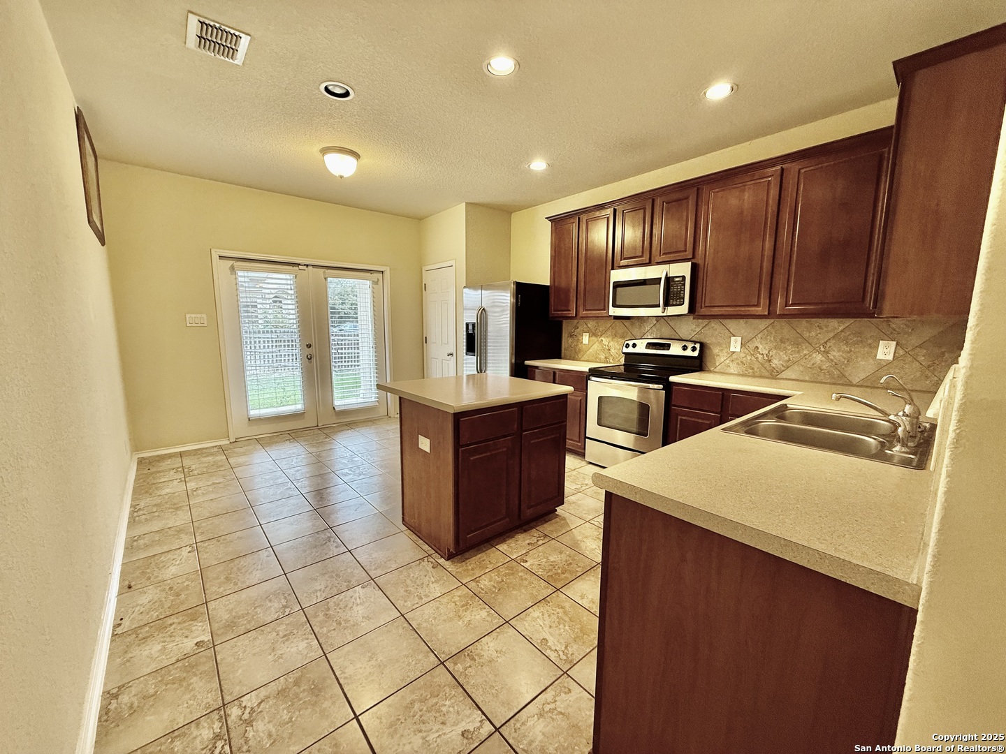 7015 Laguna Beach Converse, TX 78109 - Photo 7 of 39 a kitchen with stainless steel appliances granite countertop a sink counter space cabinets and a stove