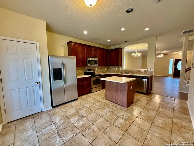a kitchen with stainless steel appliances granite countertop a refrigerator and a sink