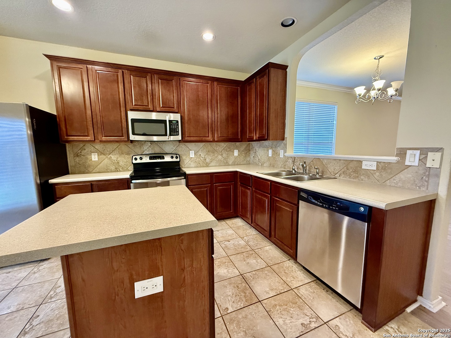 7015 Laguna Beach Converse, TX 78109 - Photo 9 of 39 a kitchen with a sink a stove a microwave and refrigerator