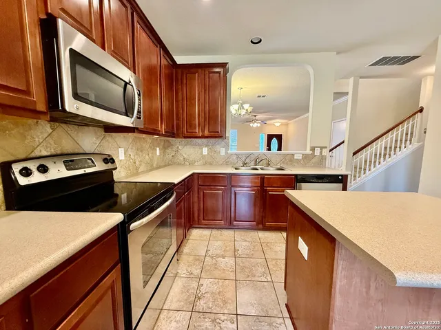 a kitchen with stainless steel appliances granite countertop a sink stove microwave and cabinets