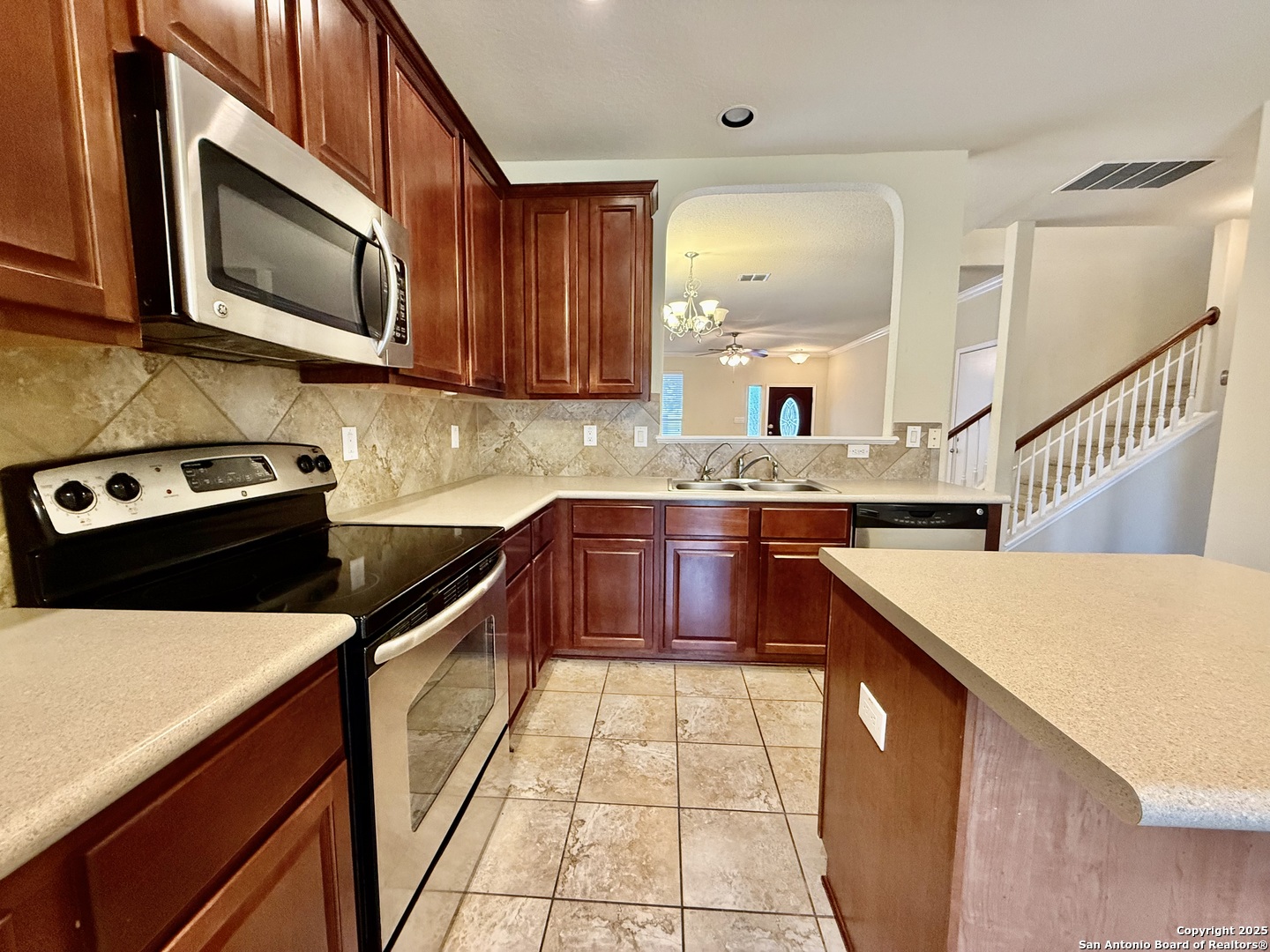 7015 Laguna Beach Converse, TX 78109 - Photo 10 of 39 a kitchen with stainless steel appliances granite countertop a sink stove microwave and cabinets