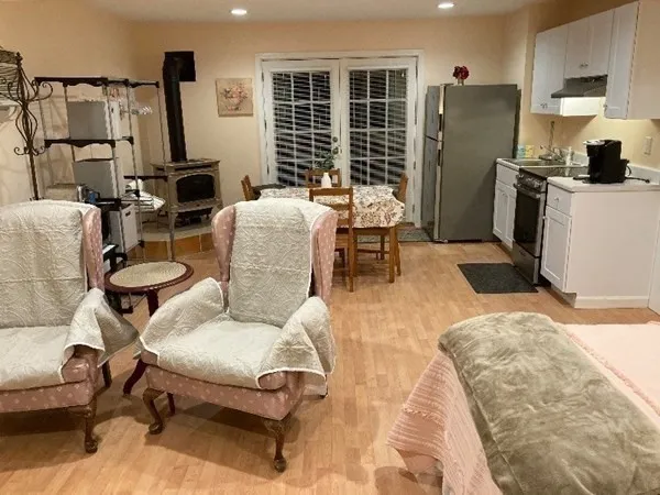 a living room with furniture a flat screen tv and a refrigerator