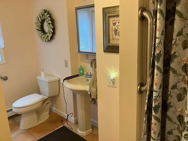 a bathroom with a granite countertop sink and a toilet