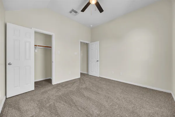 an empty room with a window and a ceiling fan