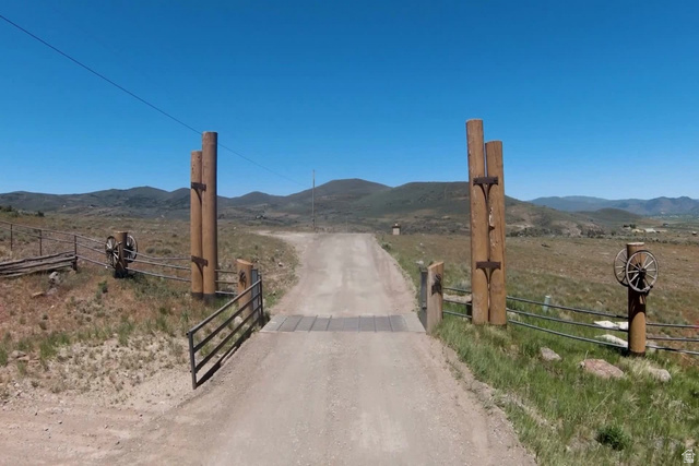 1646 North Miles Holw Road, Unit 29 Kamas, UT 84036 - Photo 35 of 35 Gated property entrance featuring a dirt road, wooden posts with wagon wheel accents, and a metal fence