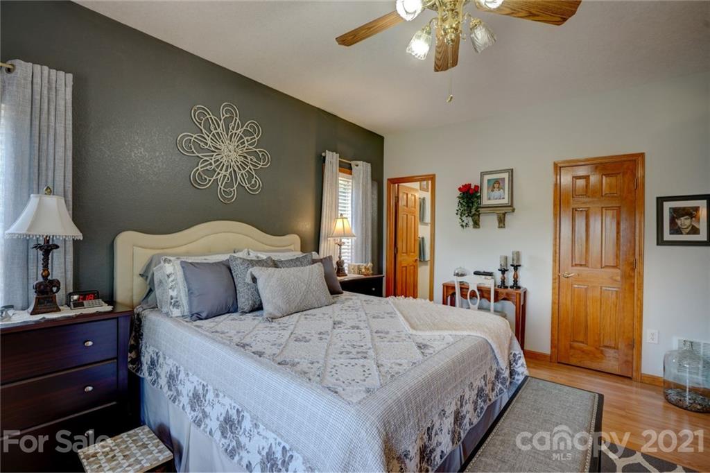 280 Robinson Gap Road Bryson City, NC 28713 - Photo 22 of 36 a bedroom with a bed and a chandelier