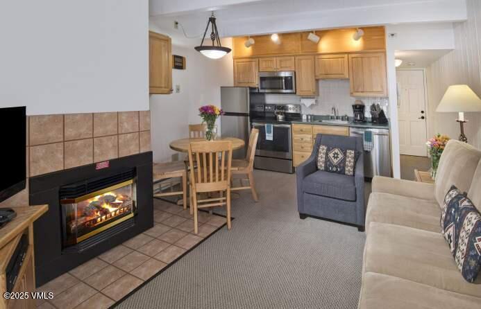 508 East Lionshead Circle, Unit 312/WEEKS 38 & 39 Vail, CO 81657 - Photo 3 of 8 a kitchen with a table chairs and a fireplace