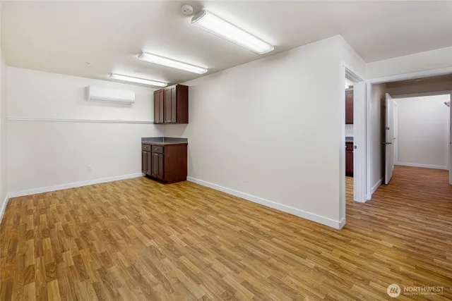 a view of a kitchen with wooden floor and electronic appliances