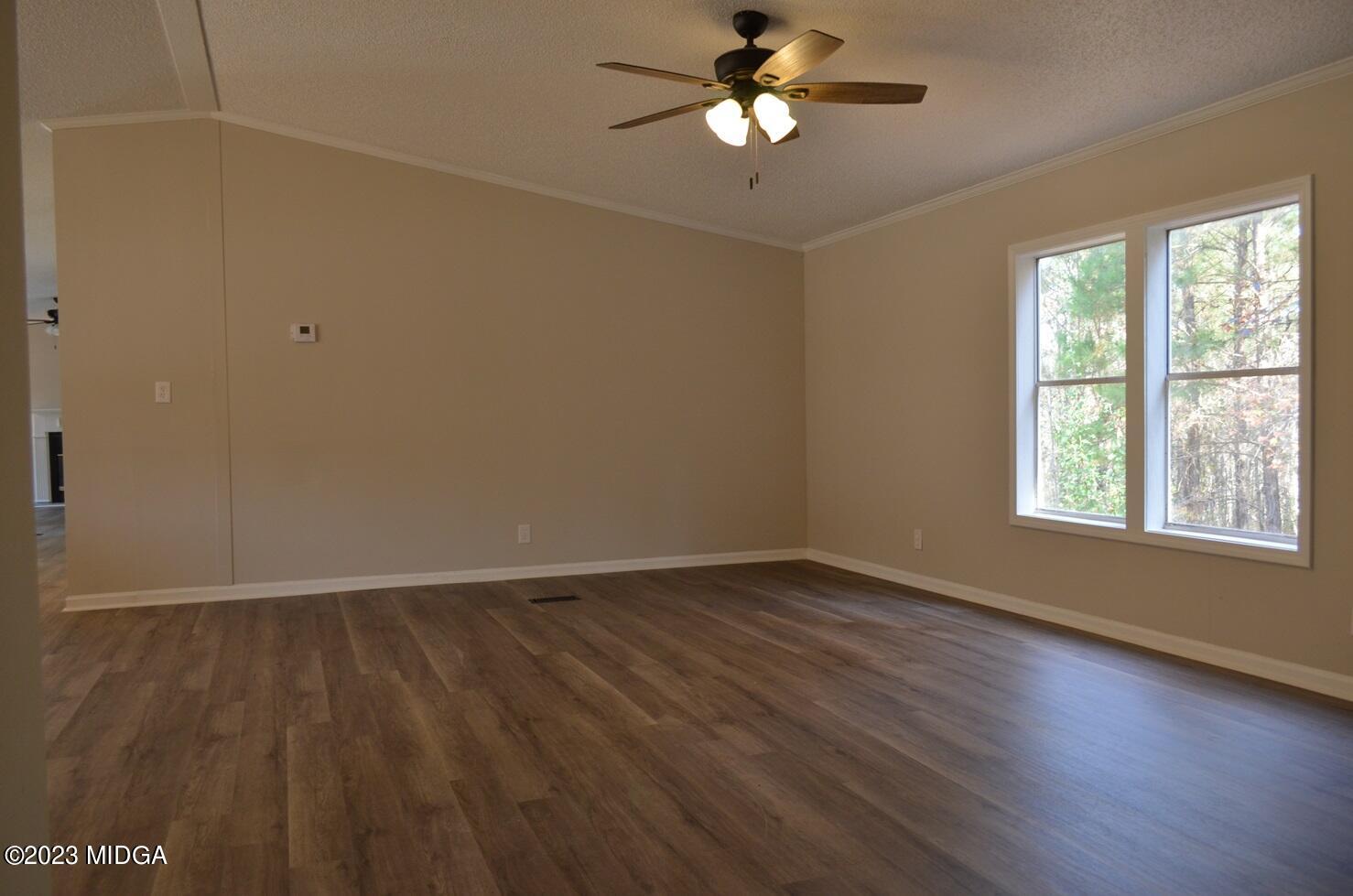 988 Lassiter Road Forsyth, GA 31029 - Photo 14 of 23 an empty room with wooden floor and windows
