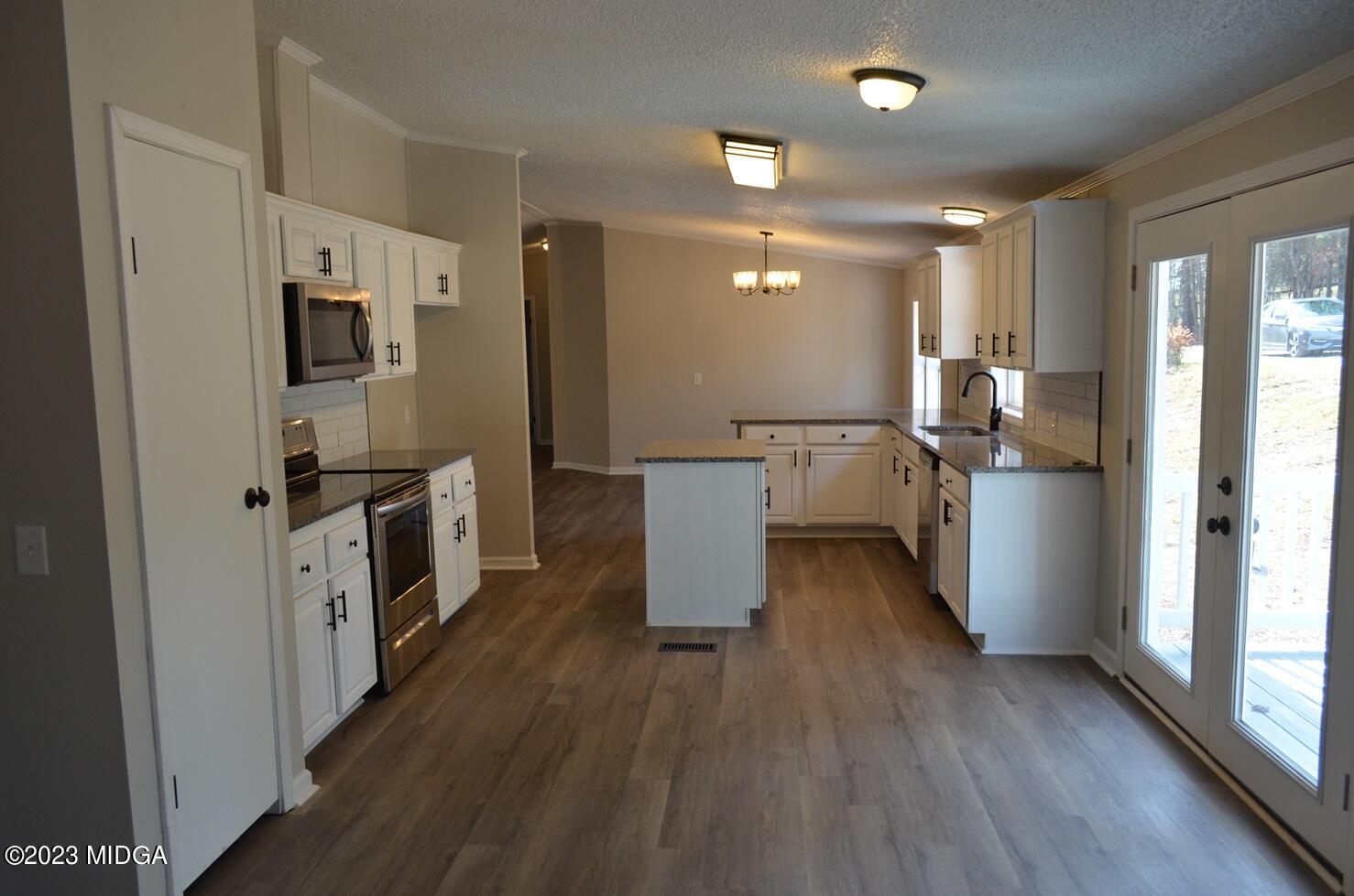 988 Lassiter Road Forsyth, GA 31029 - Photo 4 of 23 a kitchen with a refrigerator and wooden floor