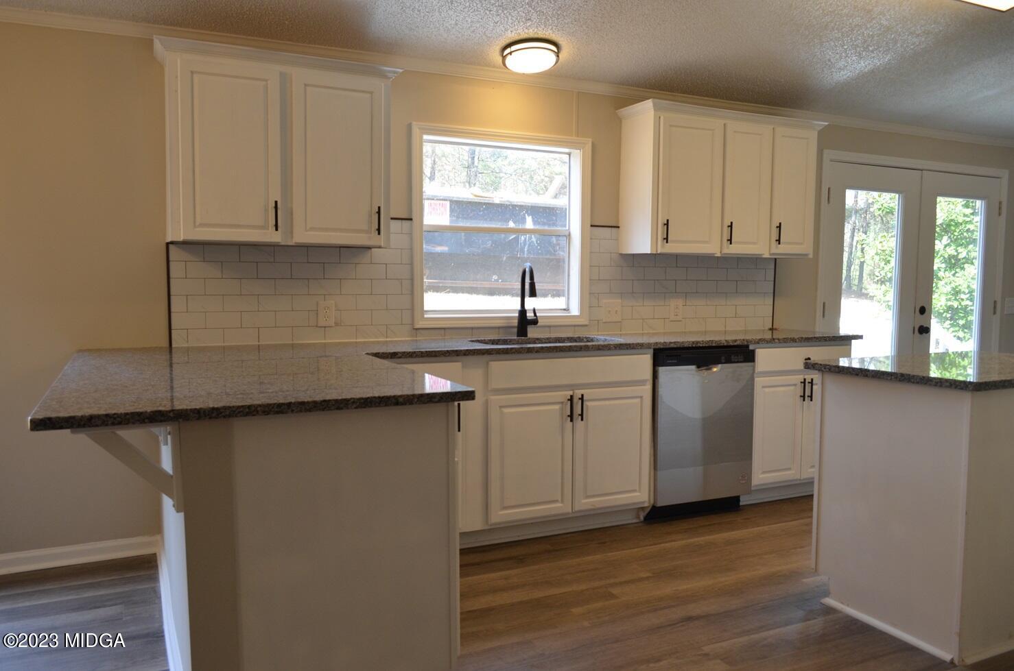 988 Lassiter Road Forsyth, GA 31029 - Photo 8 of 23 a kitchen with granite countertop white cabinets and a sink